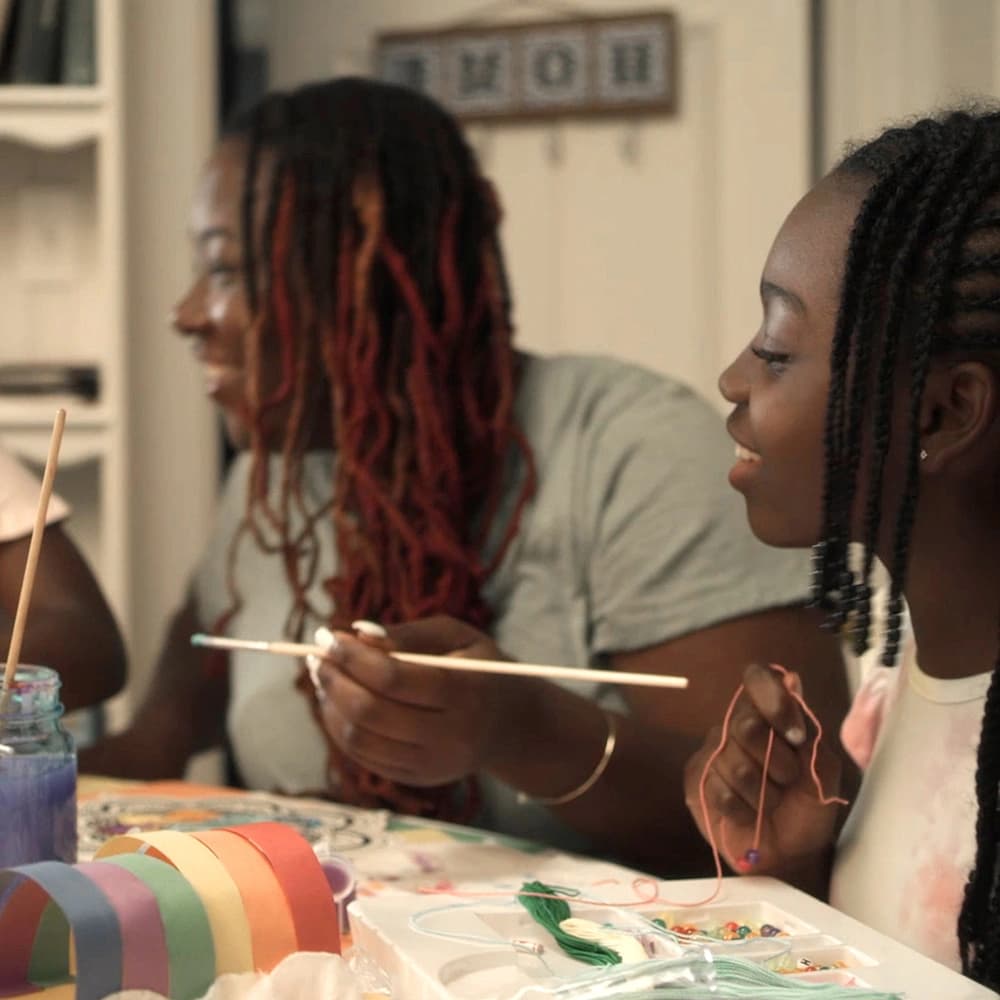 Family making arts and crafts on a table.